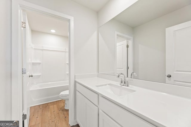 full bath with toilet, shower / bathing tub combination, wood finished floors, and vanity