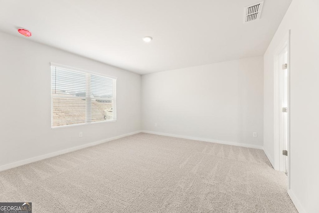 empty room featuring baseboards, visible vents, and carpet flooring