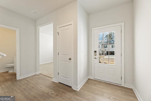 entryway featuring baseboards, visible vents, and light wood-style floors