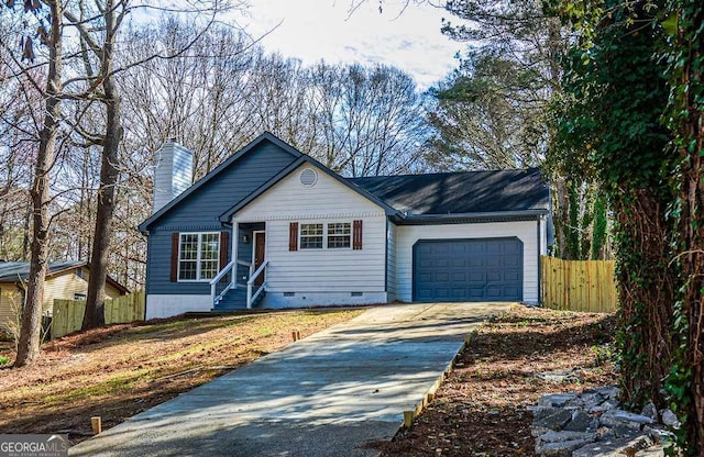 view of front of property with driveway, a chimney, crawl space, an attached garage, and fence