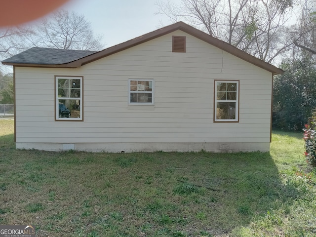 view of home's exterior featuring roof with shingles and a lawn