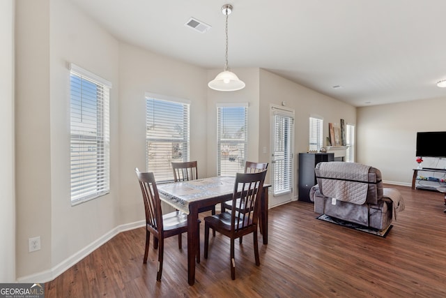 dining area with dark wood-style floors, visible vents, and baseboards