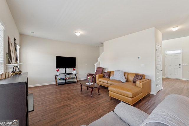 living area featuring visible vents, wood finished floors, and baseboards