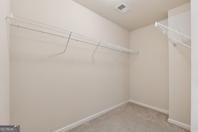 walk in closet featuring light colored carpet and visible vents