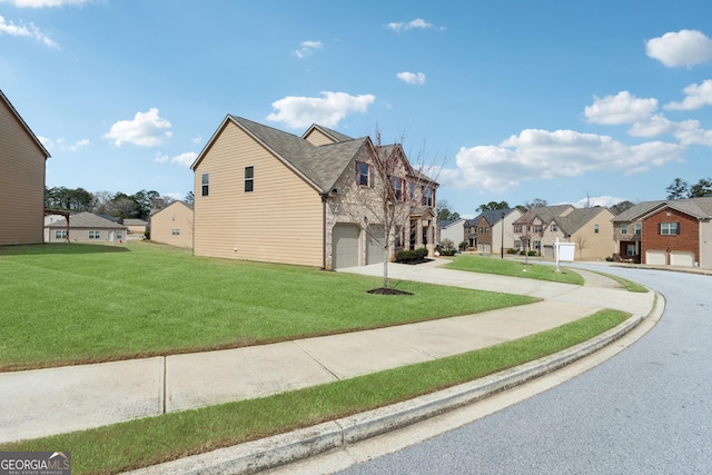 view of side of property featuring a yard, a residential view, a garage, and driveway