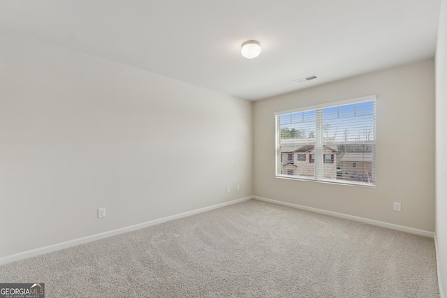 empty room featuring carpet flooring, visible vents, and baseboards