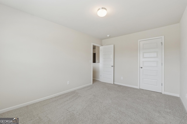 unfurnished bedroom featuring carpet flooring and baseboards