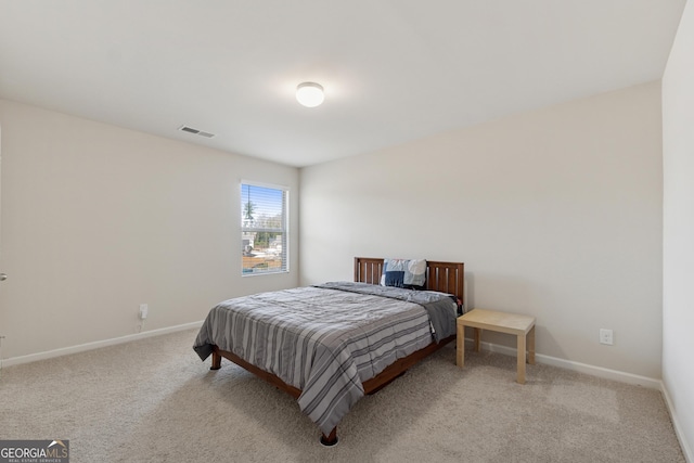 bedroom with baseboards, visible vents, and light carpet