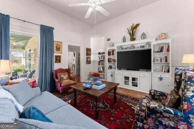 living room featuring ceiling fan, visible vents, and wood finished floors