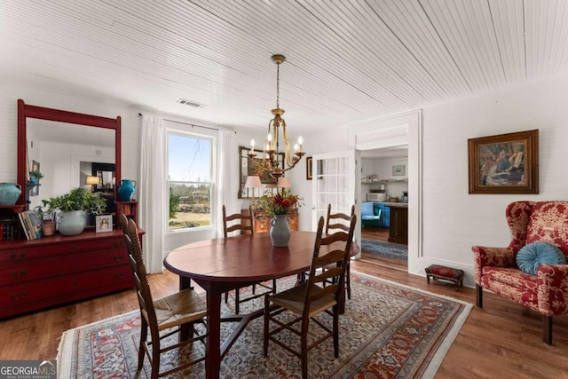 dining area with wooden ceiling, visible vents, an inviting chandelier, and wood finished floors