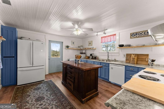 kitchen with blue cabinets, white appliances, butcher block countertops, a sink, and open shelves