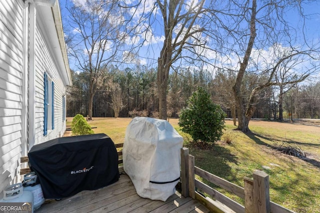 wooden deck with a lawn and a grill