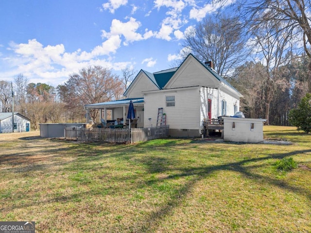 rear view of property featuring crawl space, a patio, and a yard