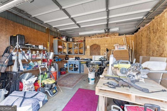 garage featuring a workshop area, metal wall, and a garage door opener