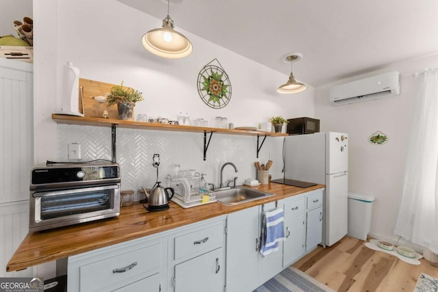 kitchen featuring a sink, wood counters, backsplash, open shelves, and a wall mounted air conditioner