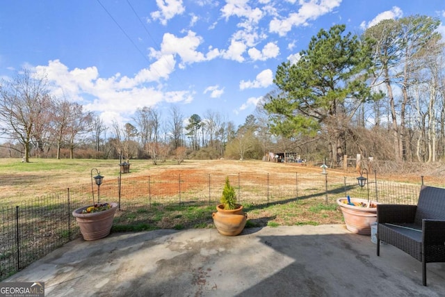 view of patio / terrace with a rural view and fence