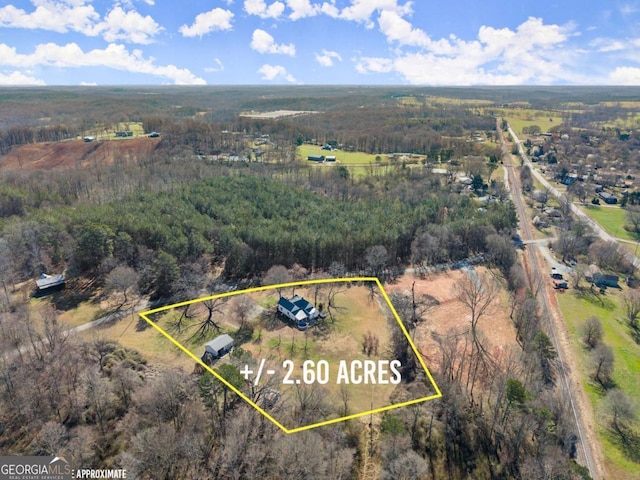 aerial view featuring a rural view and a wooded view