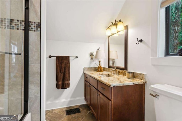 full bath with baseboards, vanity, toilet, and tiled shower