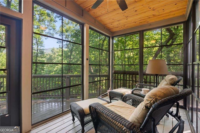 sunroom featuring lofted ceiling, wooden ceiling, and a ceiling fan