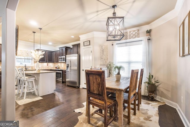 dining space with baseboards, arched walkways, dark wood-style flooring, crown molding, and a notable chandelier