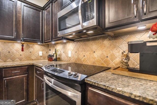 kitchen with appliances with stainless steel finishes, backsplash, dark brown cabinets, and light stone countertops