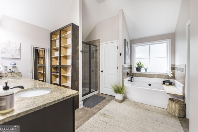 bathroom with a garden tub, vaulted ceiling, a shower stall, vanity, and tile patterned flooring