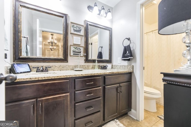 full bathroom featuring a sink, double vanity, tile patterned flooring, and toilet