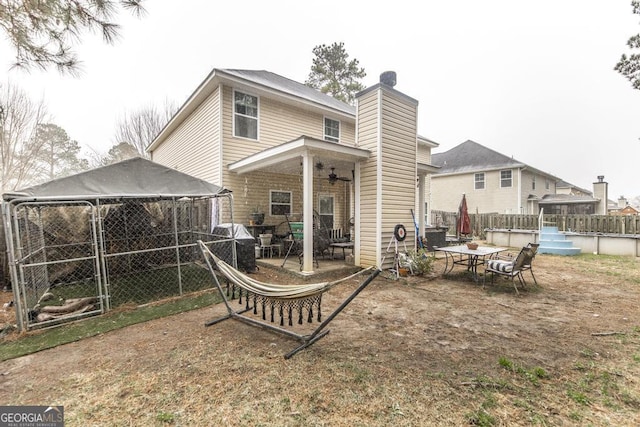 back of property featuring a ceiling fan, fence, and a patio