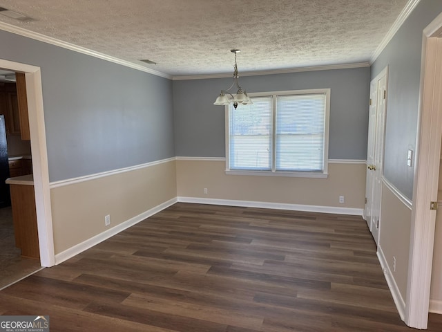 unfurnished dining area with dark wood-style floors, a chandelier, a textured ceiling, and ornamental molding