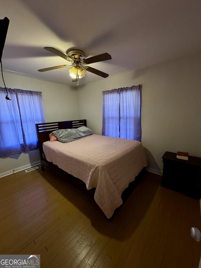 bedroom featuring a ceiling fan, baseboards, and hardwood / wood-style floors