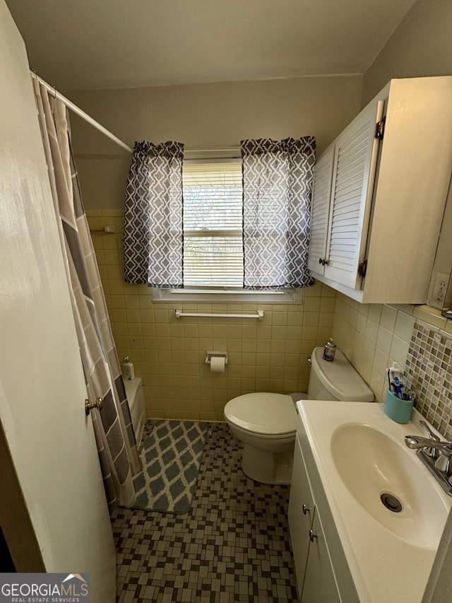 full bath featuring curtained shower, vanity, toilet, and tile walls