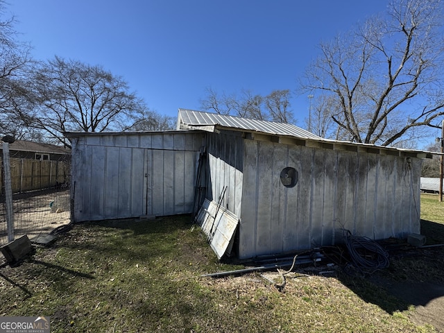 view of outbuilding featuring fence and an outbuilding