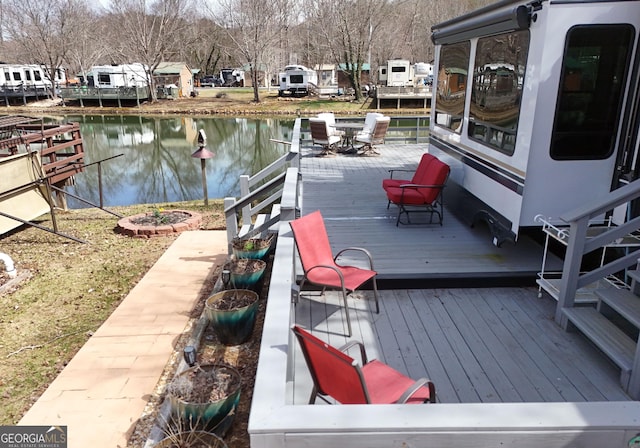 view of dock featuring a deck with water view and outdoor dining space