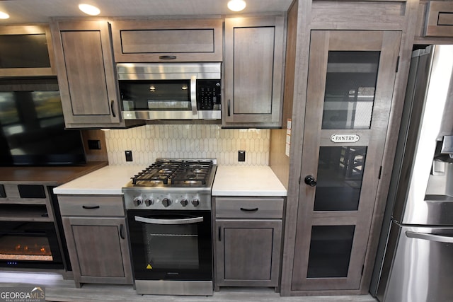 kitchen featuring light countertops, appliances with stainless steel finishes, and decorative backsplash