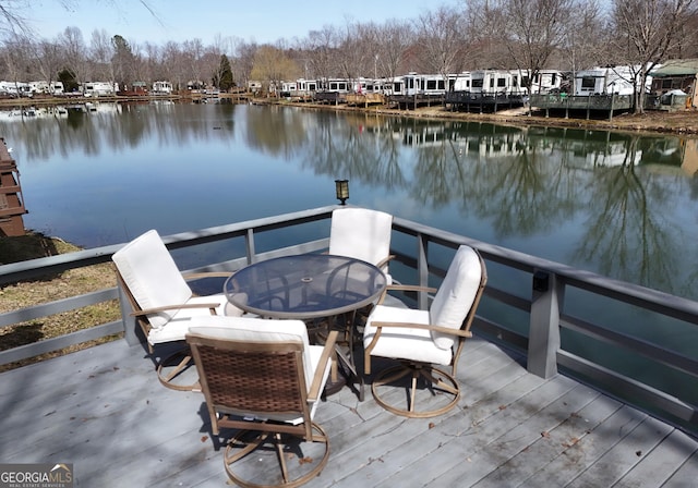 dock area with outdoor dining area and a water view