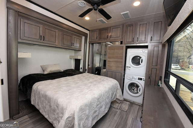 bedroom with recessed lighting, visible vents, stacked washing maching and dryer, and wood finished floors