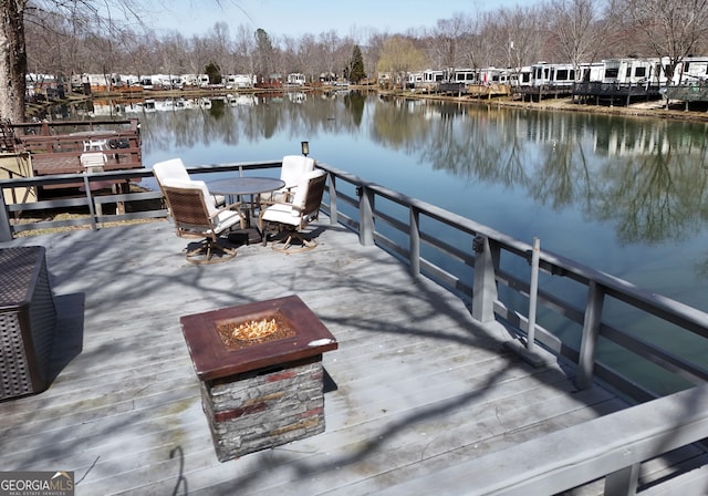 view of dock featuring a water view and an outdoor fire pit