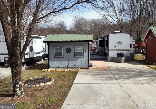 view of outdoor structure with concrete driveway and an outdoor structure