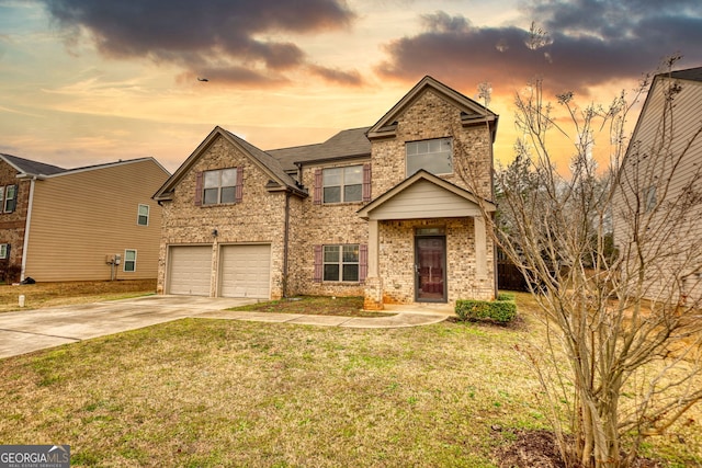 traditional home with a garage, a front yard, concrete driveway, and brick siding