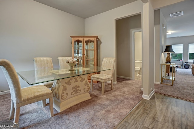 dining area featuring baseboards, carpet, visible vents, and wood finished floors