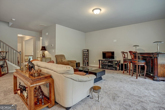 carpeted living area featuring a bar and stairs