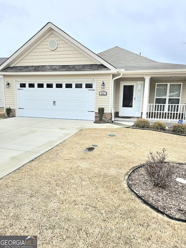 single story home with a garage, concrete driveway, and covered porch