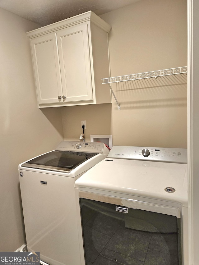 washroom featuring cabinet space and washer and dryer