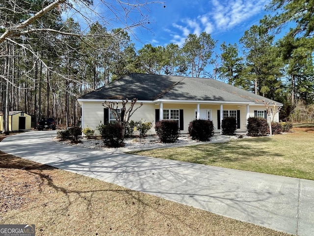 ranch-style home featuring driveway, a front lawn, and an outbuilding