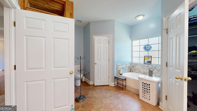 full bath with a garden tub, visible vents, toilet, tile patterned flooring, and baseboards