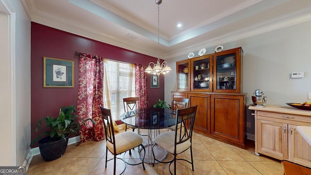 dining room with baseboards, a tray ceiling, a notable chandelier, and ornamental molding