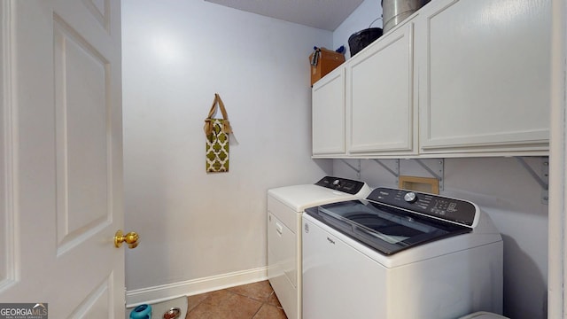 laundry room featuring washer and dryer, cabinet space, baseboards, and light tile patterned floors