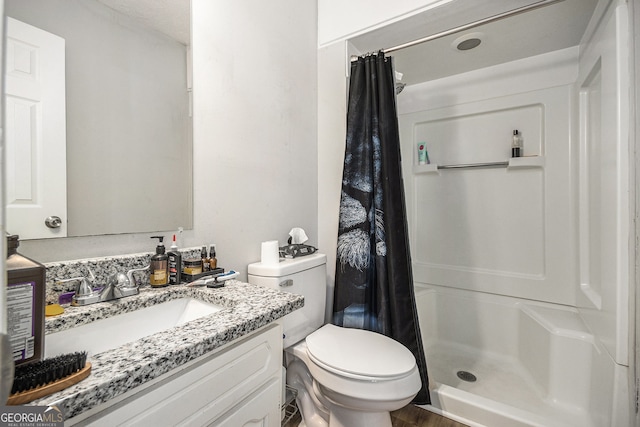 bathroom with vanity, toilet, and a stall shower