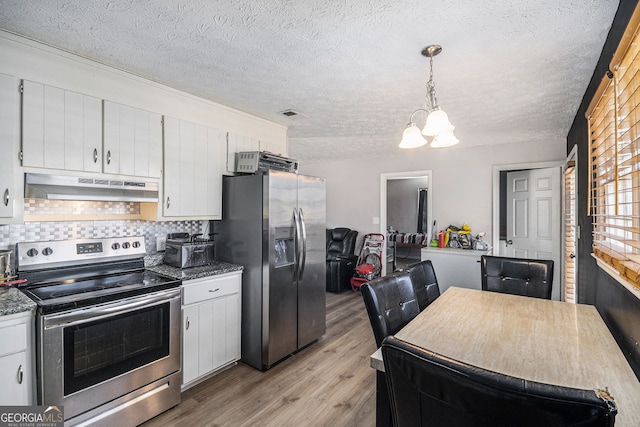 kitchen featuring light wood finished floors, stainless steel appliances, decorative backsplash, under cabinet range hood, and a notable chandelier