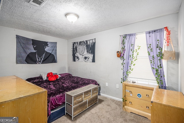 carpeted bedroom featuring baseboards, visible vents, and a textured ceiling